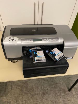 a printer sitting on top of a desk next to a cell phone