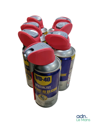 four cans of aerosol sprays are lined up on a white surface