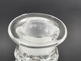 a clear glass bottle with a clear top on a black surface