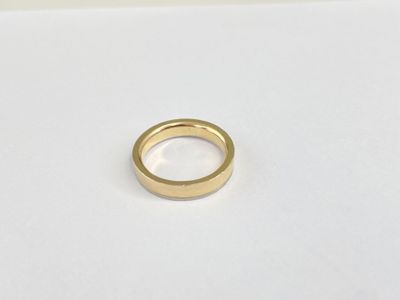 a close up of a gold ring on a white surface