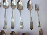 several spoons, forks and spoons are arranged on a white surface