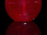an image of a red glass bottle with a cork stopper
