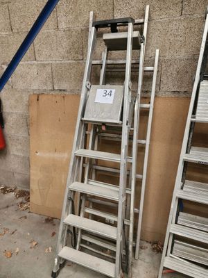 beaucoup d'échelles empilées contre un mur
