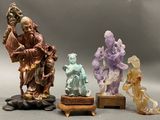 three figurines of a man and a woman on a wooden stand