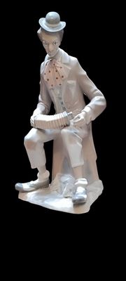 a statue of a man sitting on a stool holding a book