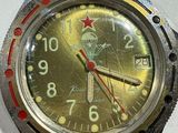 a green watch with a red second hand and a red second hand