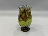un vase en verre jaune et marron posé sur une table blanche