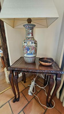 une table sur laquelle se trouvent une lampe et un vase