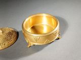 an image of a gold plate with a lid on a table
