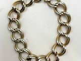 gros plan d'un bracelet en chaîne en argent sur une surface blanche