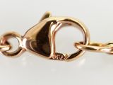 a close up of a gold chain with a heart on it