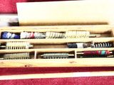 several brushes in a wooden box on a red carpet