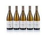 three bottles of white wine are lined up on a white surface