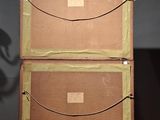 two pieces of luggage sitting on top of a wooden stand
