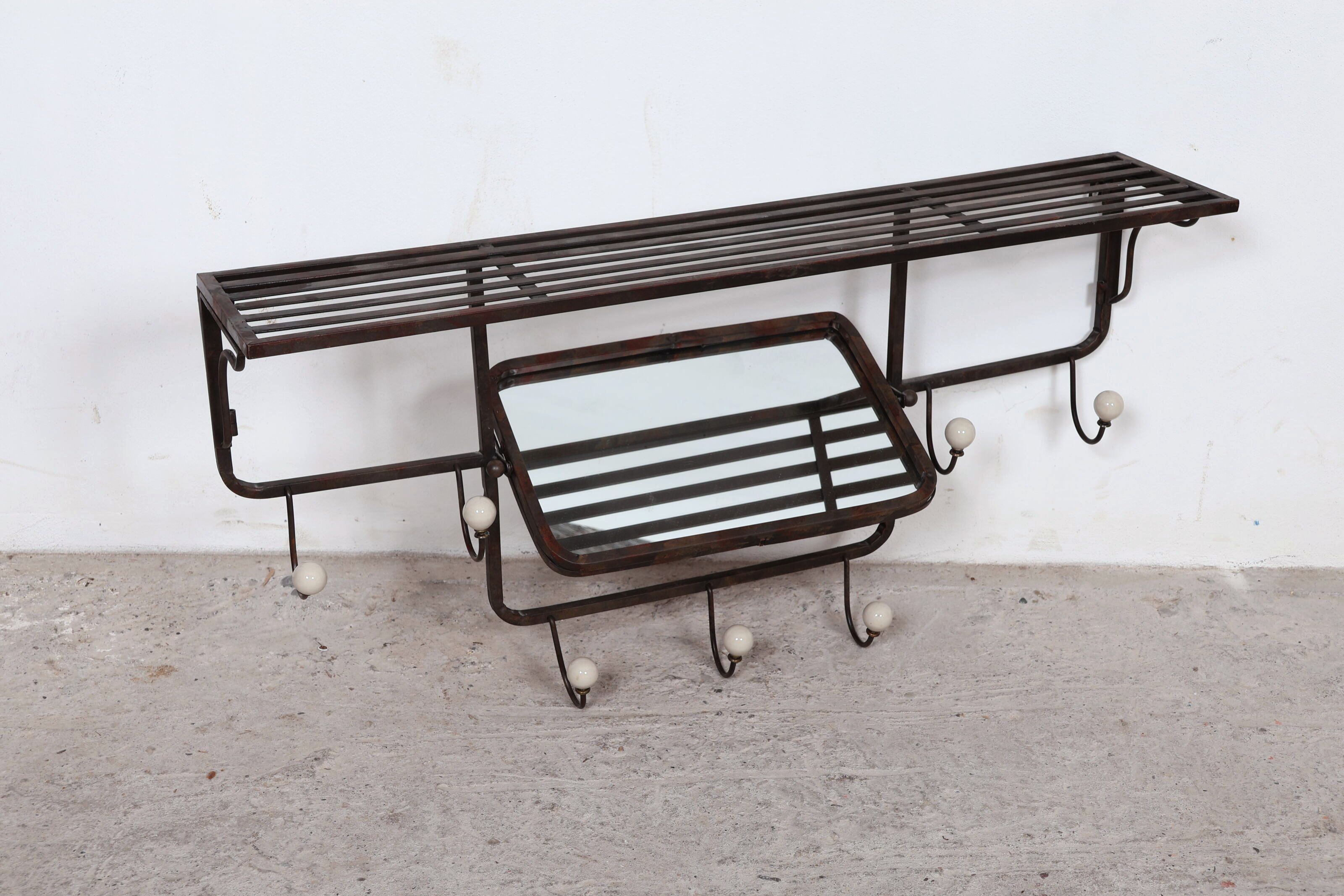 Porte-manteaux en fer forgé et boules de porcelaine, centré d'un miroir pivotant. Circa 1950. H_50 cm L_97 cm P_20,5 cm