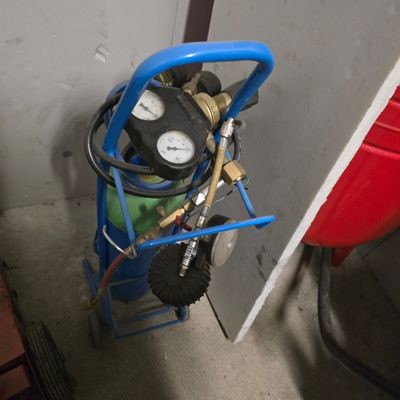 a blue cart with a pressurer and a gauge on it