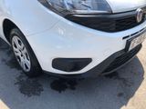 the front end of a white car parked in a parking lot