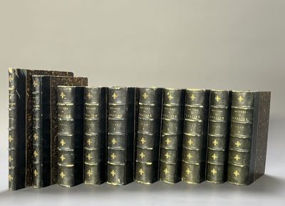 several old books are lined up in a row on a table