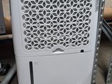 a white air conditioner sitting on the floor in a warehouse