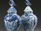 deux vases bleus et blancs surmontés d'oiseaux