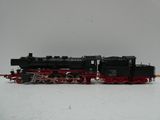 un train noir et rouge sur les rails, dans la neige