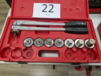 une mallette rouge contenant des outils, posée sur une table