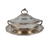 a silver plate with a silver lid and a saucer on it