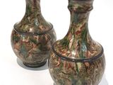 two vases that are sitting on a white surface