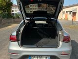 the back of a silver car with its trunk open on a gravel road