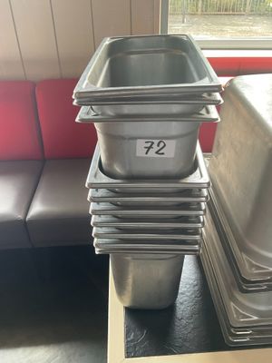Plusieurs plateaux de nourriture sont empilés sur une table dans un restaurant