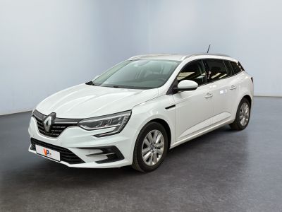 Une voiture blanche est garée dans une pièce au sol noir.