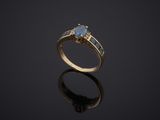 a gold ring with a blue topaz stone and two diamonds
