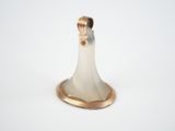 a white and gold candle holder on a white surface