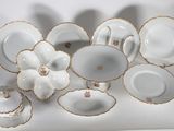 beaucoup de vaisselle blanche et dorée sur une table blanche