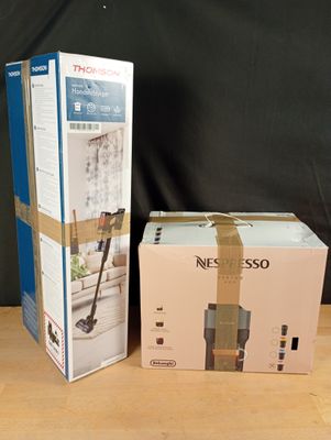 two boxes on a table with a vacuum and a cordless mop in them