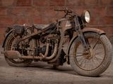 a old motorcycle that is parked in front of a brick wall