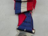 silver medal with red, white, and blue ribbon on a white surface