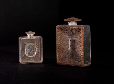 pair of antique glass perfume bottles on a black background