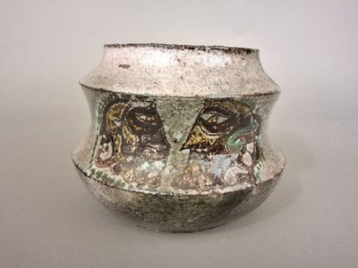 a white vase with a design on it on a table