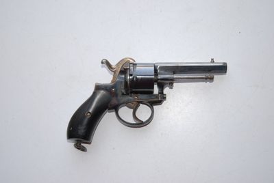an old revolver is laying on a white surface