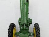 a green toy tractor that is sitting on a white surface