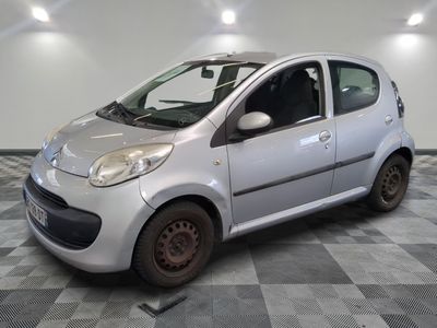 une petite voiture argentée garée sur un sol en damier