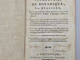 un livre ouvert avec une écriture dessus, posé sur une table