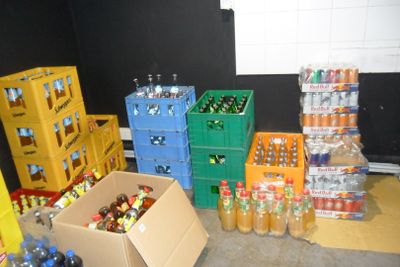 many boxes of sodas and bottles of soda in a room