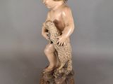 an antique statue of a child holding a teddy bear on a base