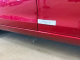 a red car that has a sticker on the side of it