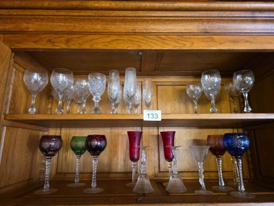 de nombreux verres à vin posés sur une étagère dans un placard