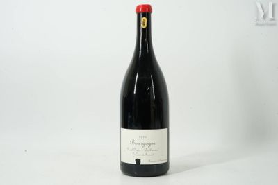 une bouteille de vin rouge posée sur une table blanche