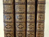 cinq vieux livres sont empilés les uns sur les autres sur une table