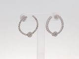 une paire de boucles d'oreilles créoles en diamant exposées sur un fond blanc